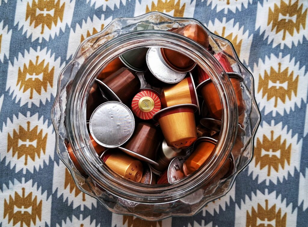 Cápsulas de café acumuladas num frasco de vidro 