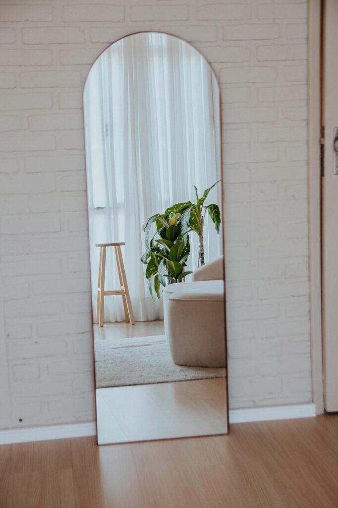 Interior calmo com espelho, luz natural e plantas, representando uma casa que funciona sem esforço